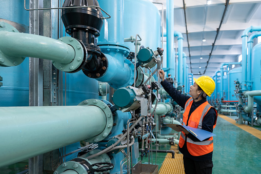 An Asian female engineer checks the equipment in the chemical plant