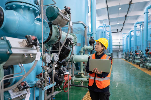 una ingeniera trabaja en una planta química usando una computadora portátil - boiler power station fuel and power generation gas boiler fotografías e imágenes de stock