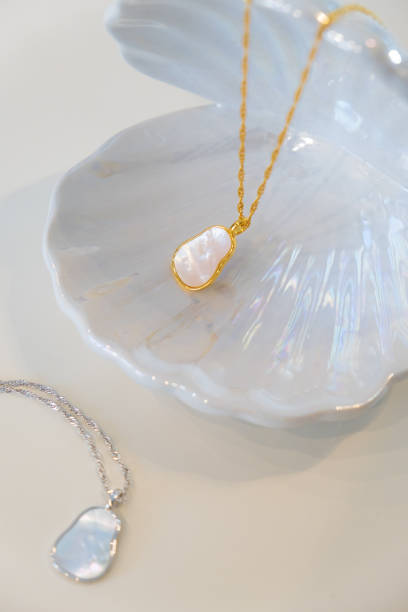 istock Golden and silver chain pearl necklaces on white 1452167047