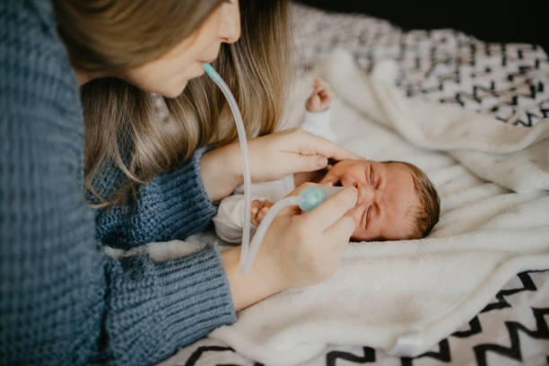 istock Mother using nasal aspirator for her son at home 1452172890