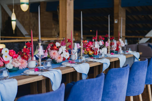 istock Table setting at the wedding reception. Floral compositions with beautiful flowers and greenery, candles, laying and plates on decorated table. 1452173123