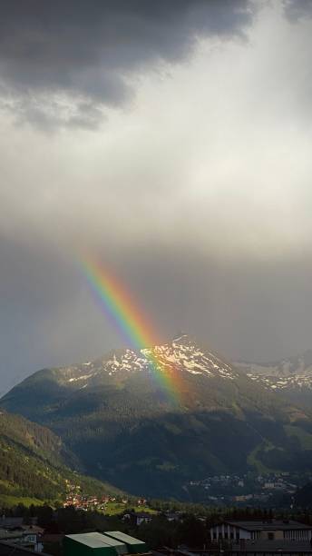 istock Vertical aerial view of rainbow in dark sky over mountains 1452176021