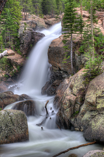 A rush of water casacades over rocky falls in the Rocky Mountain National Park backcountry in summer.
