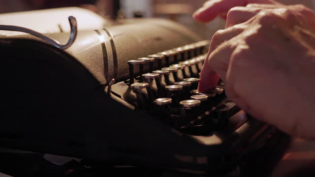 man typing on a vintage typewriter