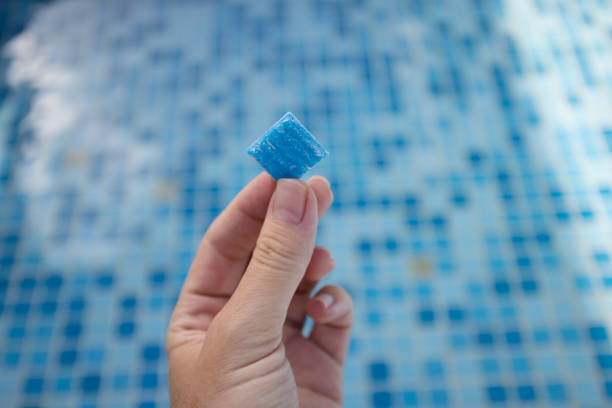 istock Hand holding small tile from floor of swimming pool. Tile from pool bottom cover. 1452201836
