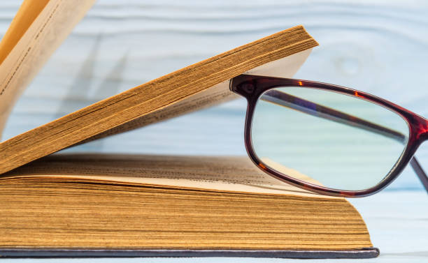 istock Reading glasses on an open book. Idea for reading books 1452204298