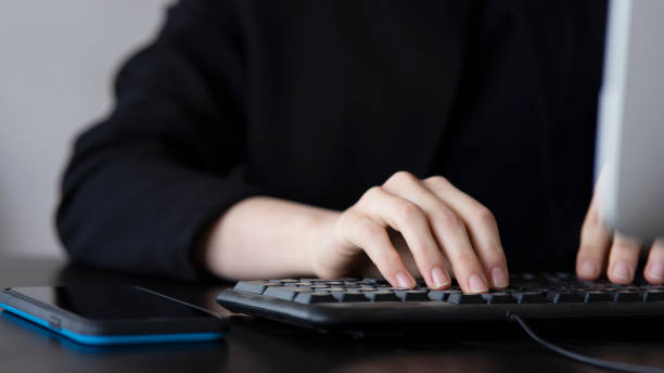 Female office worker typing on the keyboard stock photo