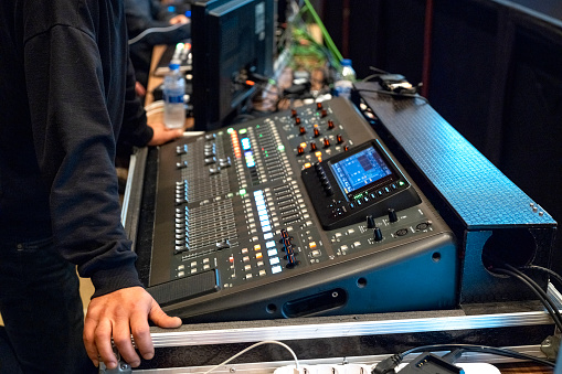 Online broadcast of the event.\nVideo switcher of Television Broadcast with blurry background, working with video and audio mixer, control broadcasts in recording studio