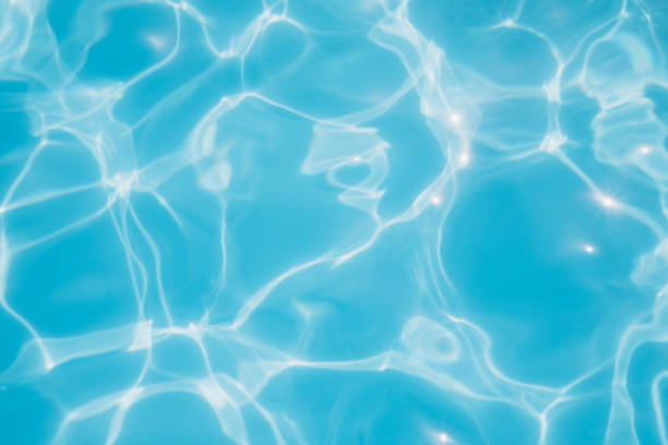 istock Background, blue water waves in the pool with sun reflection. Selective focus 1452219868