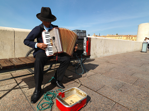 Senior Spanish men making music in street on Roman Bridge of Cordoba. April 08, 2015