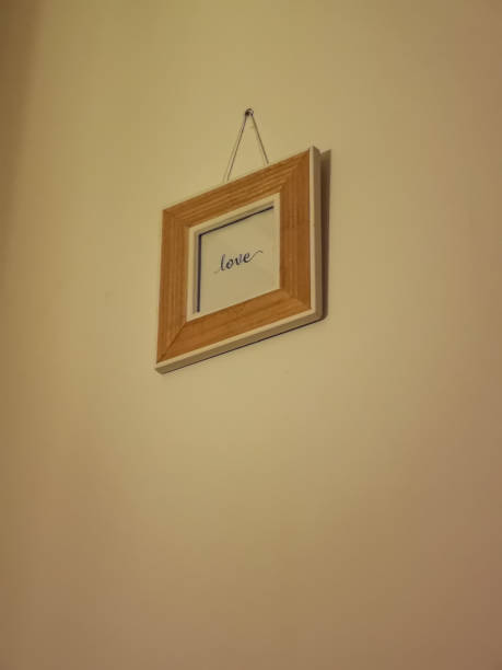 istock Small square wooden frame hanged on the wall with Love word inside 1452230092