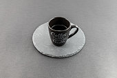 Black small mug of coffee with light letterings on it