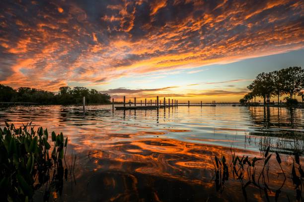 Fiery red and orange clouds and reflections on Lake Dora in Florida stock photo