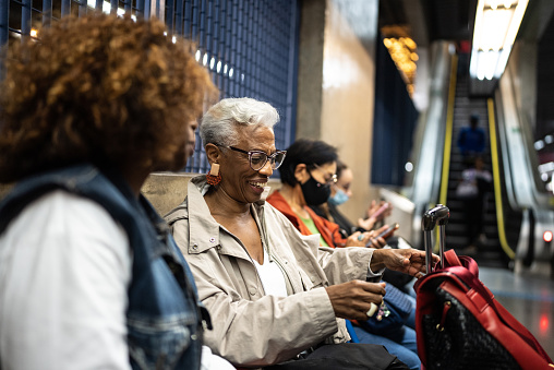 Senior friends talking while waiting in the subway