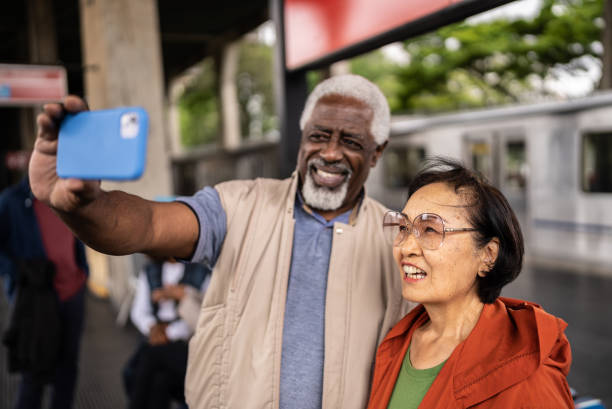 istock Senior friends taking a selfie or filming using mobile phone in a subway station 1452234241