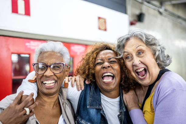 Senior friends embracing in a subway