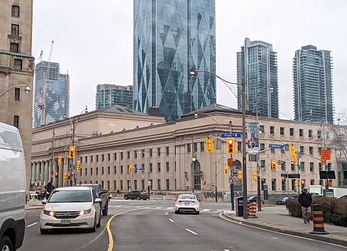 Toronto, Canada - December 7, 2022: Traffic curves along University Avenue near Front  Street West outside historic Union Station. Background shows the modern CIBC Square on Bay Street and residential towers. Autumn morning.