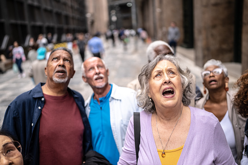 Shocked senior tourists looking up outdoors
