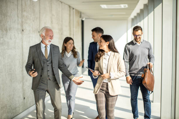 Group of business people walking through hallway and talking