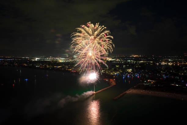 istock Aerial view of bright fireworks exploding with colorful lights over sea shore on US Independence day holiday 1452245376