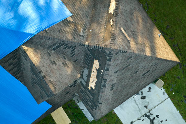 istock Hurricane Ian damaged house rooftop covered with protective plastic tarp against rain water leaking until replacement of asphalt shingles. Aftermath of natural disaster 1452245401