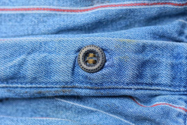 istock brown metal button on a blue fabric 1452245534