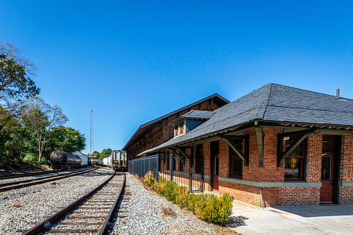 Carrollton, Georgia, USA-Oct. 20, 2022: The Old Depot on Bradley  (formerly Carrollton Train Depot) was built circa 1888 and played a key role in the area's textile industry. It has been restored and now a banquet hall. The railroad tracks are still active.