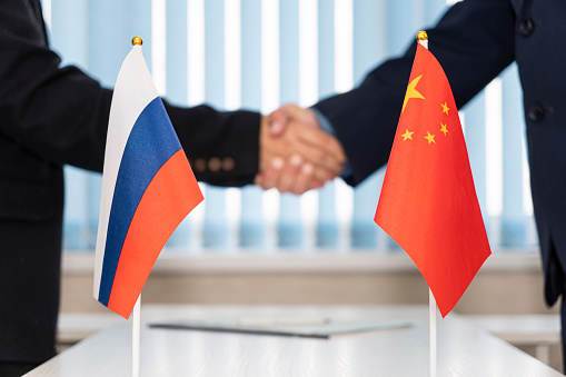 Political flags of russia and chinese on table in international negotiation room. concept of negotiations, collaboration and cooperation of countries. agreement between the governments.