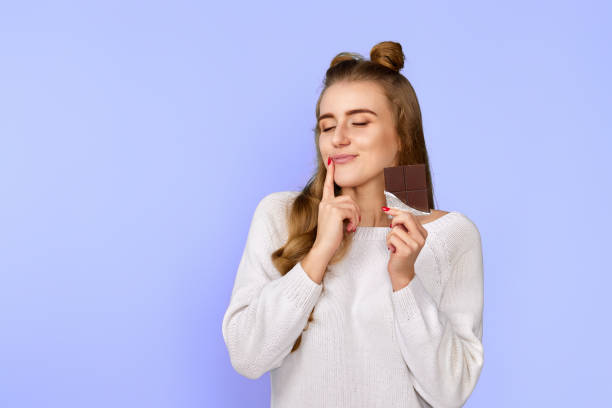 istock charming cute dreamy woman enjoying dark chocolate 1452254864