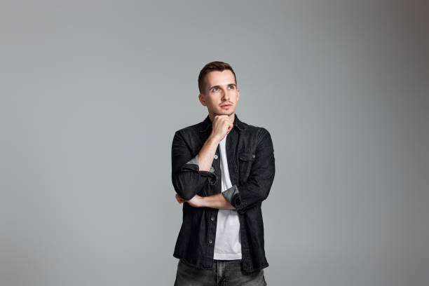 istock thoughtful man holding arms folded, touching chin with hand 1452254896