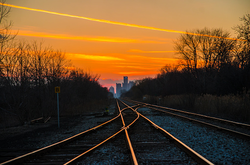Train tracks at sunset in Windsor, Ontario, with the downtown Detroit skyline in the background.