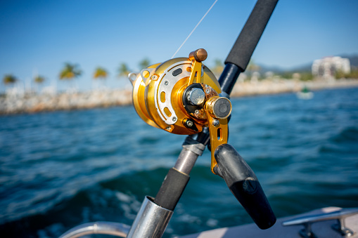 Large Ocean Fishing Reel on a Rod used for Catching Big Game Fish Such as Mahi Mahi, Tuna, Sailfish and Marlin on a Boat Near a Marina in Puerto Vallarta Mexico
