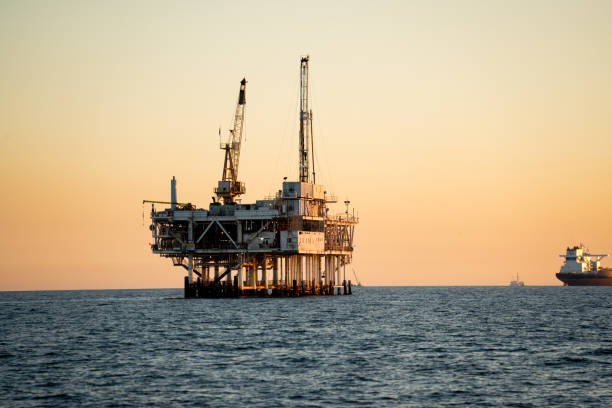 고요한 저녁에 어두워지기 직전에 롱비치와 로스앤젤레스 근처의 남부 캘리포니아 해안 근처에서 원유와 천연 가스를 위한 거대한 해양 석유 플랫폼 굴착 장치 시추 및 파쇄 - oil rig sea oil storm 뉴스 사진 이미지