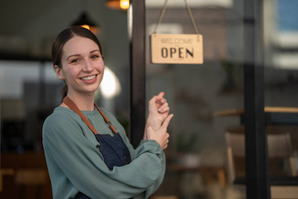 istock A beautiful young coffee shop owner holds an open sign. 1452267590