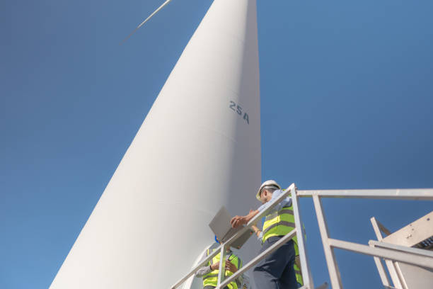 istock Asian engineer working in fieldwork outdoor. Workers check and inspect construction and machine around building project site. Wind turbine for electrical of clean energy and environment sustainable. 1452278876