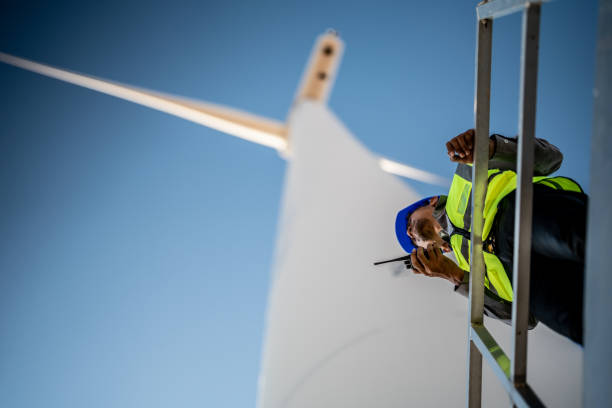 istock Asian engineers working in fieldwork outdoor. Workers check and inspect construction and machine around building project site. Wind turbine for electrical of clean energy and environment sustainable. 1452278921