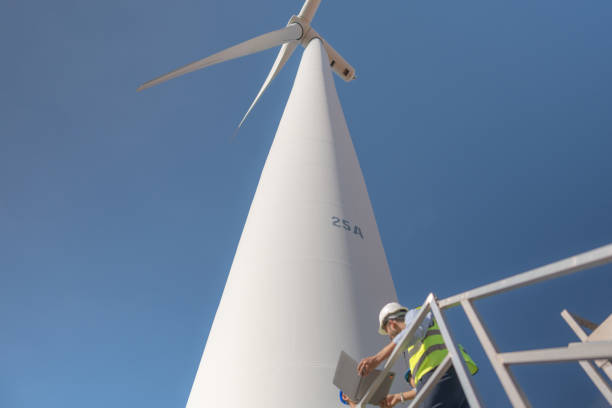 istock Asian engineer working in fieldwork outdoor. Workers check and inspect construction and machine around building project site. Wind turbine for electrical of clean energy and environment sustainable. 1452279639