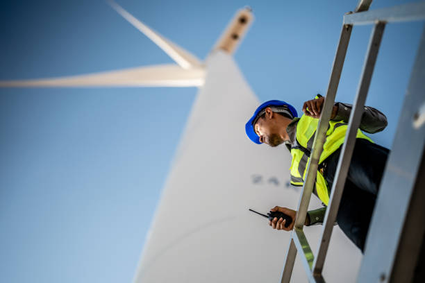 istock Asian engineers working in fieldwork outdoor. Workers check and inspect construction and machine around building project site. Wind turbine for electrical of clean energy and environment sustainable. 1452280366