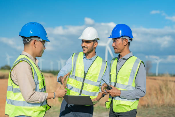 istock Asian engineers working in fieldwork outdoor. Workers walking and inspect construction and machine around project site. Wind turbine electrical of clean resource enerdy and environment sustainable. 1452280380