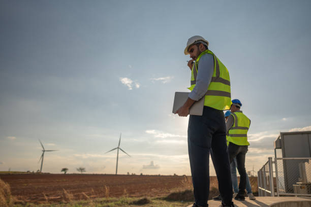 istock Asian engineer working in fieldwork outdoor. Worker sitting and inspect construction and machine around project site. Wind turbine electrical of clean resource energy  and environment sustainable. 1452288657