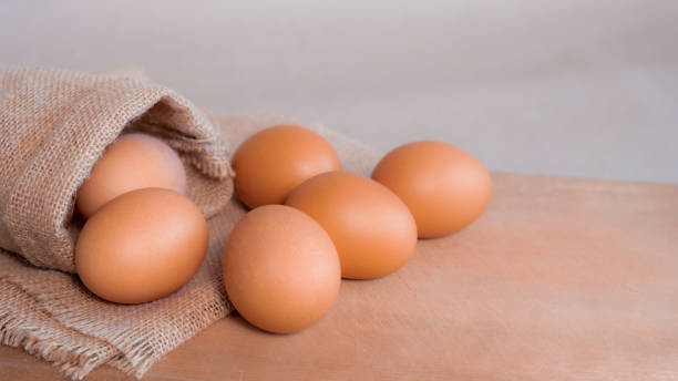 istock fresh organic chicken eggs. on sack and brown wooden board, 1452302934