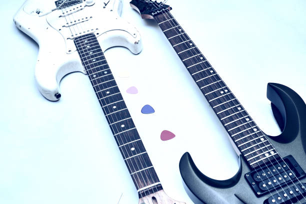 istock Two guitar, neck fretboard mediators plectrum on a pale blue.Black, white 1452308012