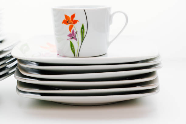 Arrange empty coffee cup and coaster on top of book and decorate with flower on the table, Elegant style