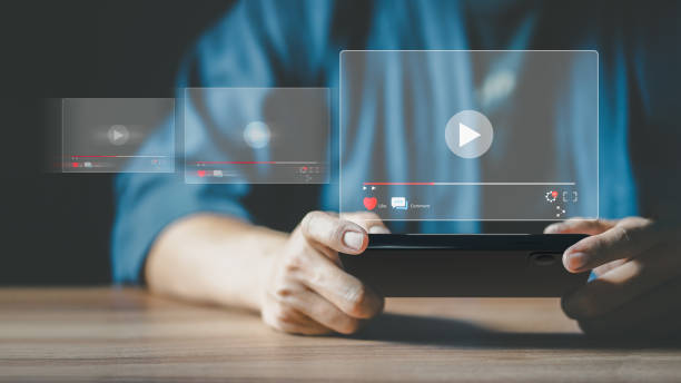 istock Man using a smartphone or mobile phone for streaming online on virtual screen, searching video on internet, live football, show or tutorial, watching the movies, content online. 1452309277