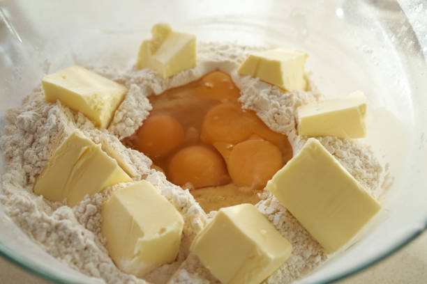 Butter, wheat flour and eggs in a glass bowl - preparation for baking cookies