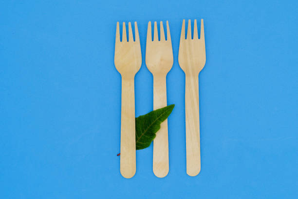 istock Disposable wooden fork and knife on blue background. Eco-friendly materials. No single-use plastics. Save the planet 1452315489