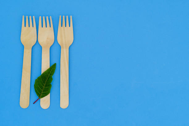 istock Disposable wooden fork and knife on blue background. Eco-friendly materials. No single-use plastics. Save the planet 1452315512
