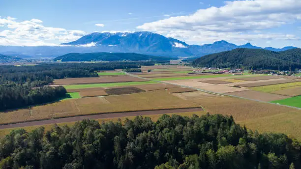 Aerial view of an agricultural area in Carinthia, Austria with mountains in the background