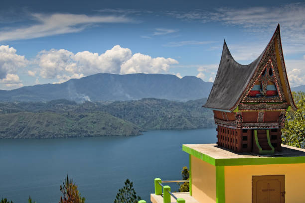 Model of a historic Batak house with lake Toba in background, Samosir, North Sumatra, Indonesia Model of a historic Batak house with lake Toba in background, Samosir, North Sumatra, Indonesia lake toba indonesia stock pictures, royalty-free photos & images