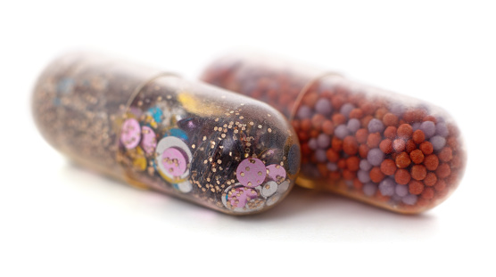 Sequins in a capsule together with other capsule isolated on a white background.